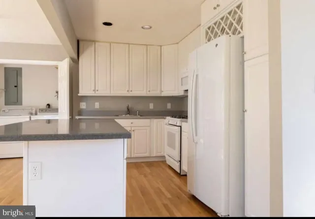 a kitchen with white cabinets and white appliances