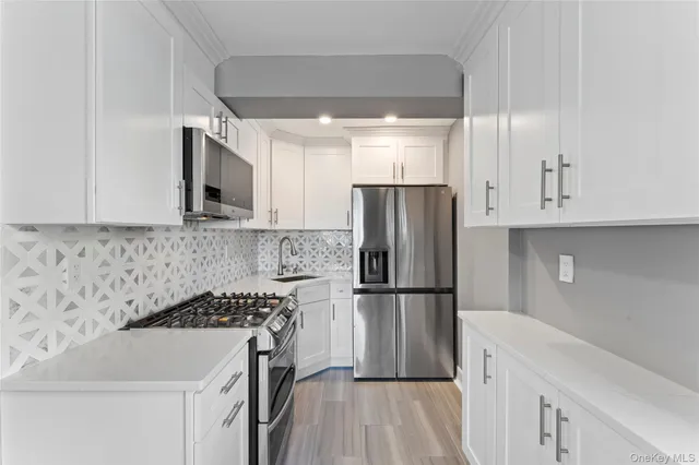 a kitchen with a sink a refrigerator and a stove top oven