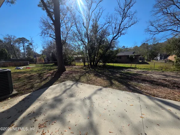 a view of a yard with wooden fence
