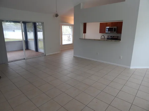 an empty room with windows and cabinet