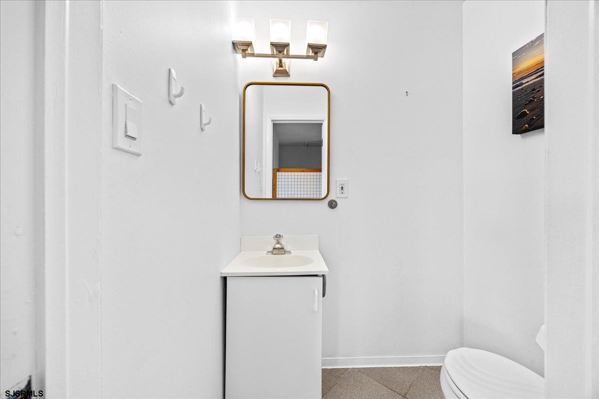 211 2nd Street South, Unit 2 Brigantine, NJ 08203 - Photo 12 of 35 a bathroom with a toilet sink and mirror