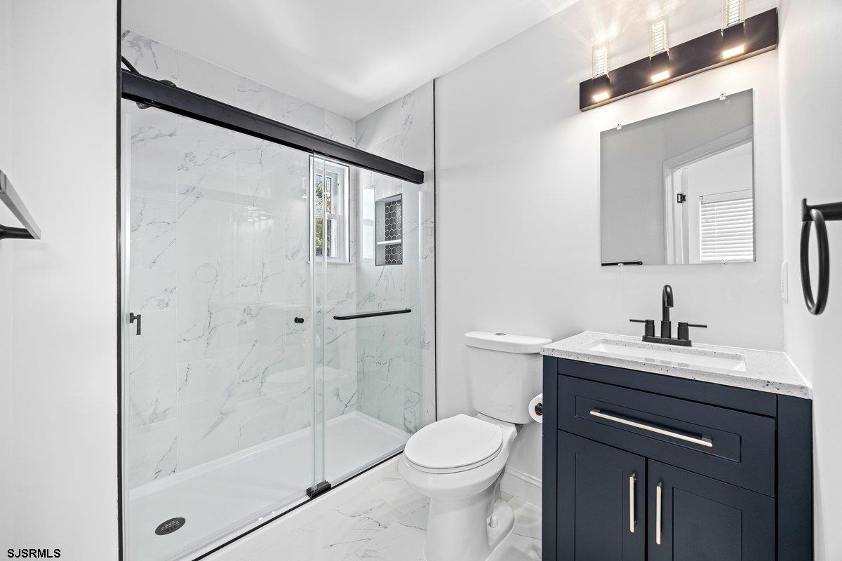 211 2nd Street South, Unit 2 Brigantine, NJ 08203 - Photo 15 of 35 a bathroom with a sink a toilet and shower