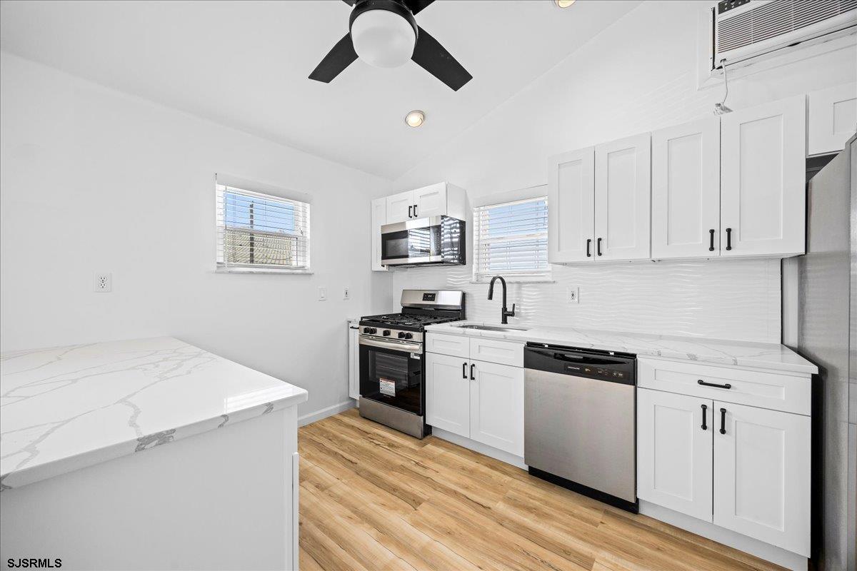 211 2nd Street South, Unit 2 Brigantine, NJ 08203 - Photo 10 of 35 a kitchen with cabinets appliances and a wooden floor