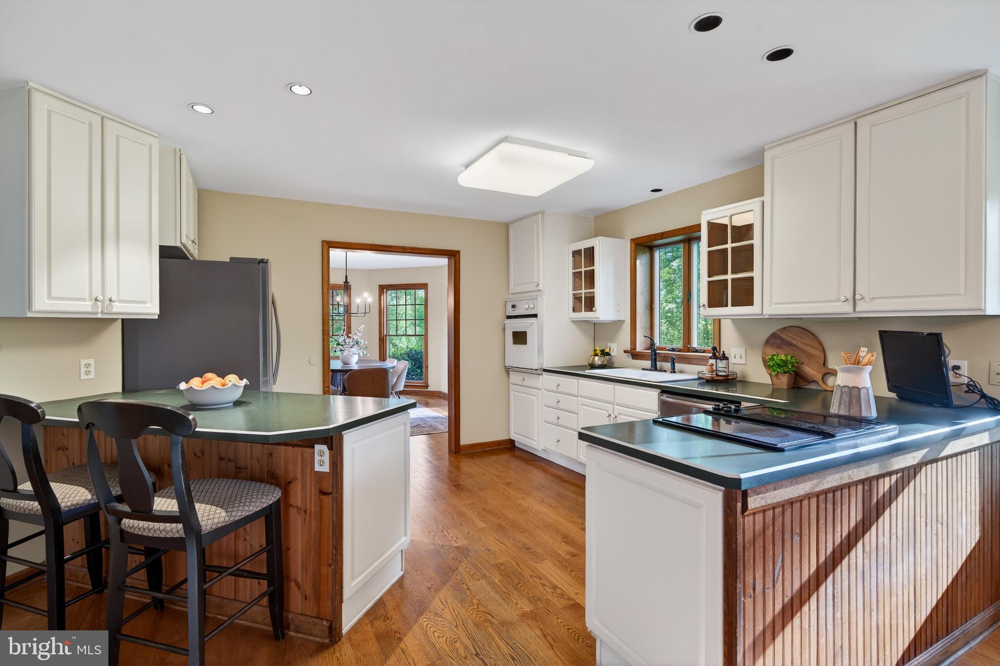 52 Atwater Road Chadds Ford, PA 19317 - Photo 20 of 85 a kitchen with stainless steel appliances granite countertop a stove a sink dishwasher a microwave oven with a dining table and chairs