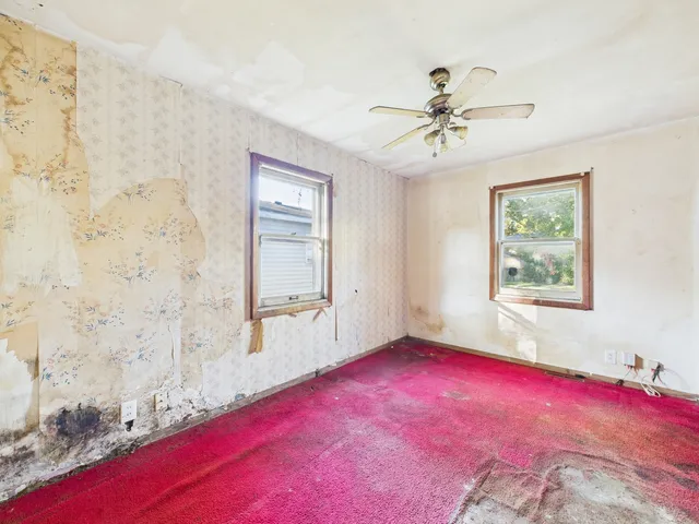 a view of a livingroom with a ceiling fan and window