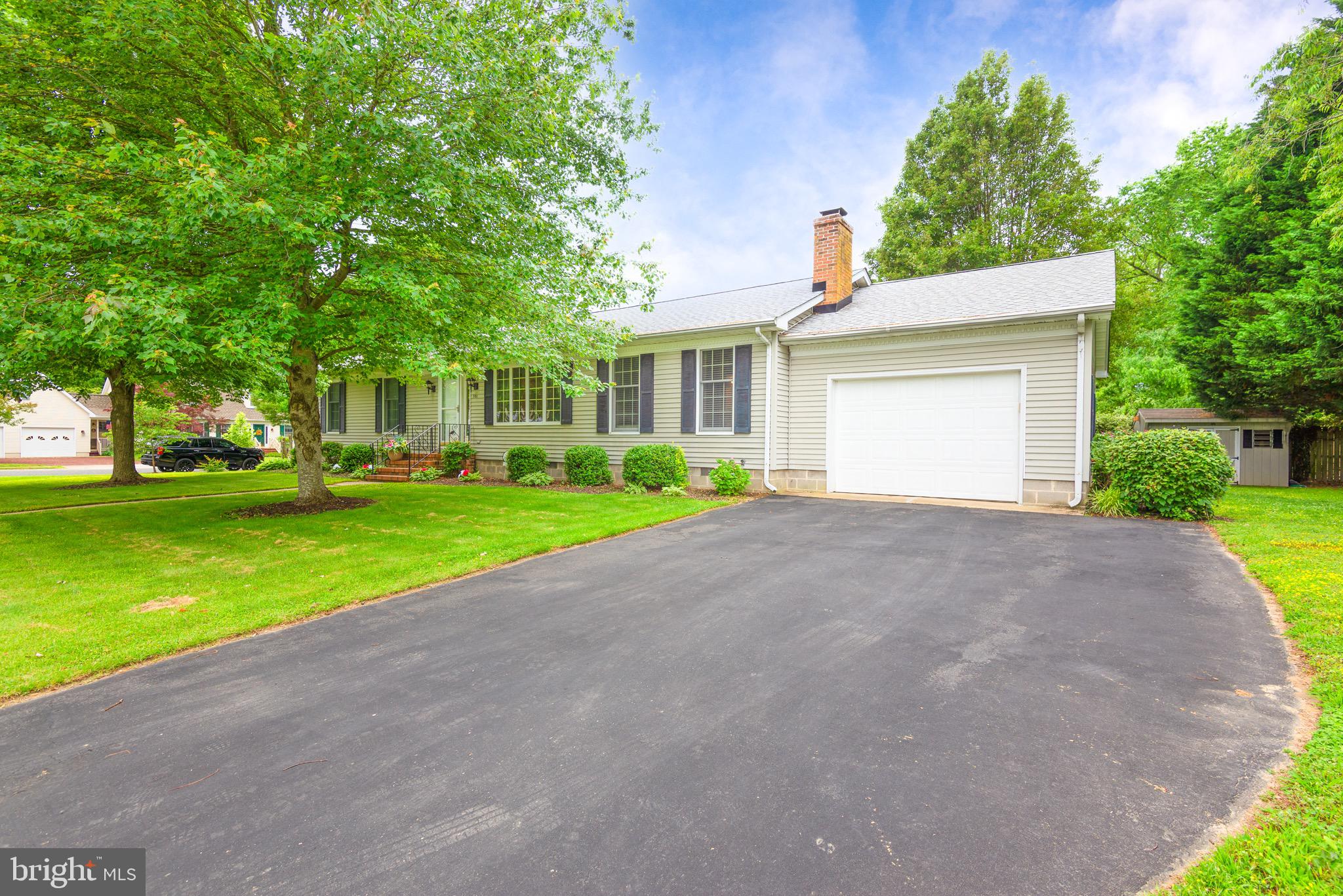 a view of a house with a yard and large tree