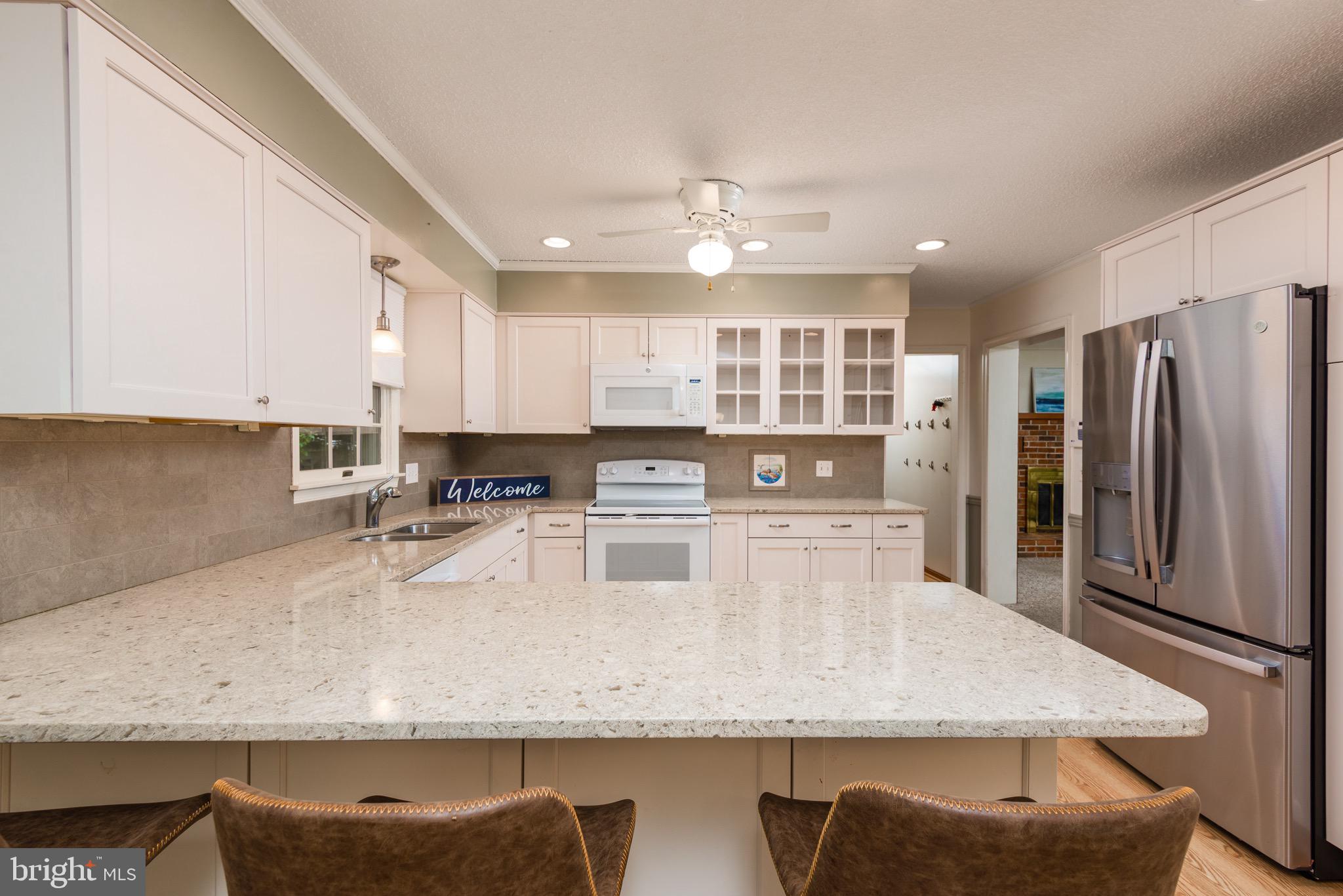 301 Spring Drive Easton, MD 21601 - Photo 11 of 32 a kitchen with kitchen island granite countertop a counter top space cabinets and stainless steel appliances