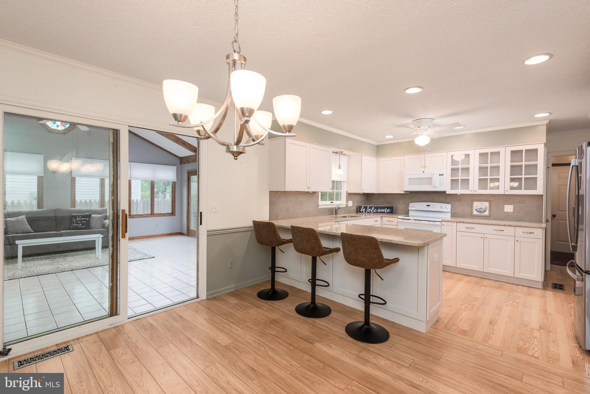 301 Spring Drive Easton, MD 21601 - Photo 7 of 32 a kitchen with stainless steel appliances kitchen island granite countertop a table chairs and a refrigerator