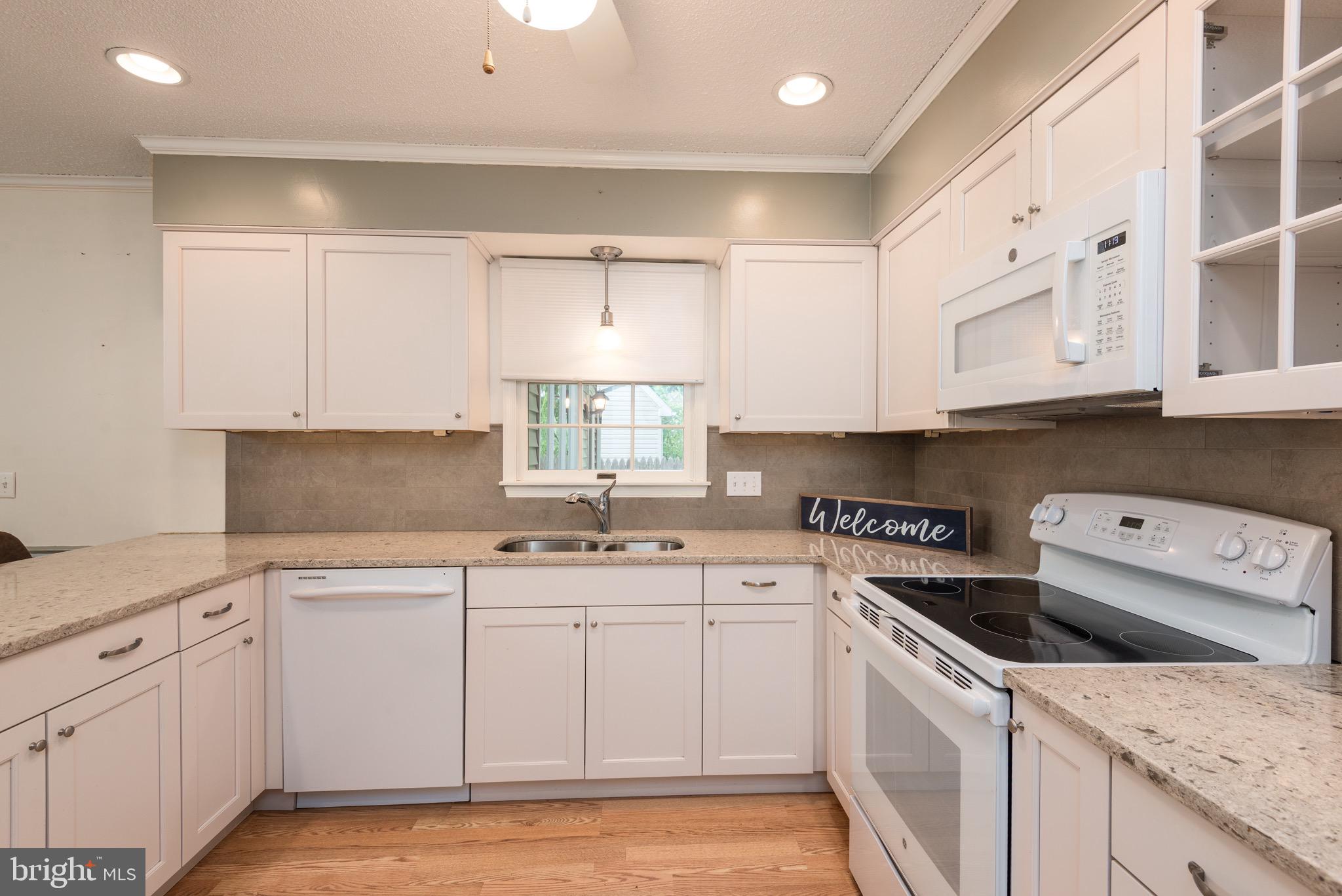 301 Spring Drive Easton, MD 21601 - Photo 10 of 32 a kitchen with a sink a stove a microwave and cabinets