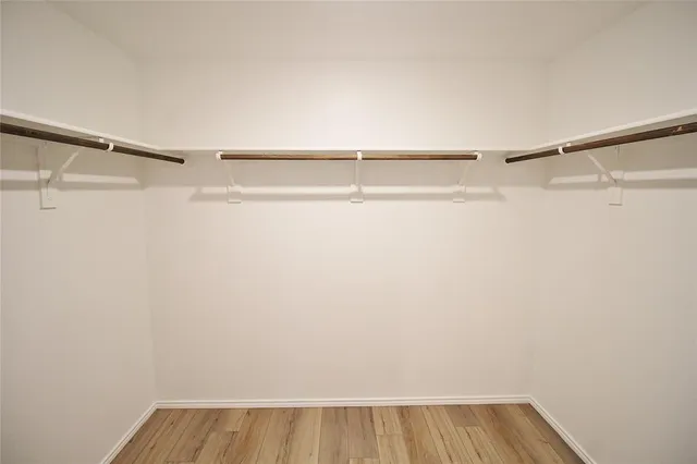 a view of walk in closet with empty racks