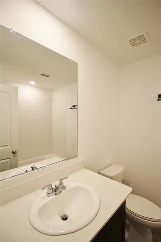 a bathroom with a sink a toilet and mirror