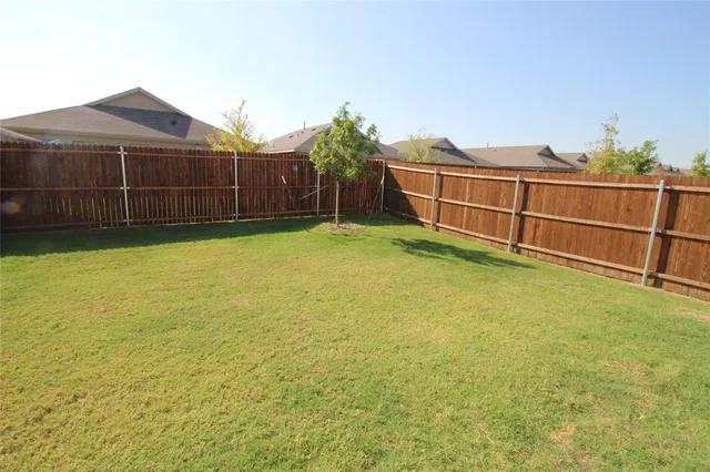 a view of a yard with wooden fence