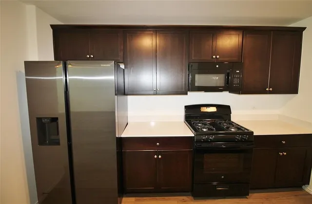 a kitchen with stainless steel appliances wooden cabinets and a sink