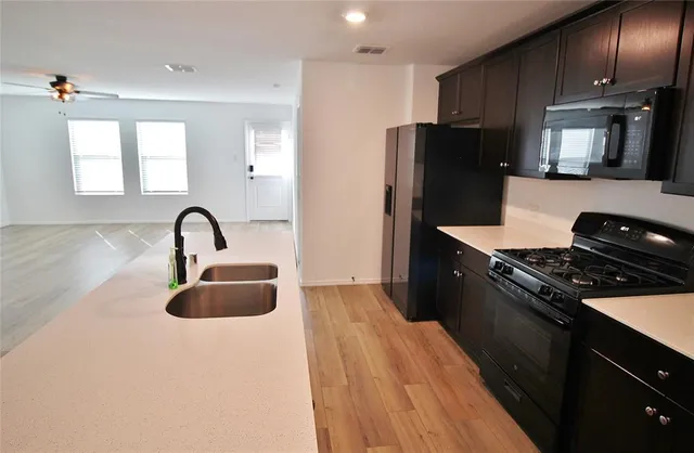 a kitchen with granite countertop a refrigerator stove and sink