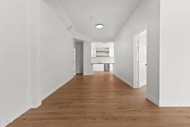 a view of empty room with wooden floor