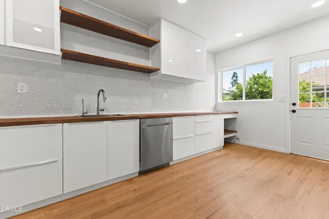 a kitchen with a sink cabinets and wooden floor