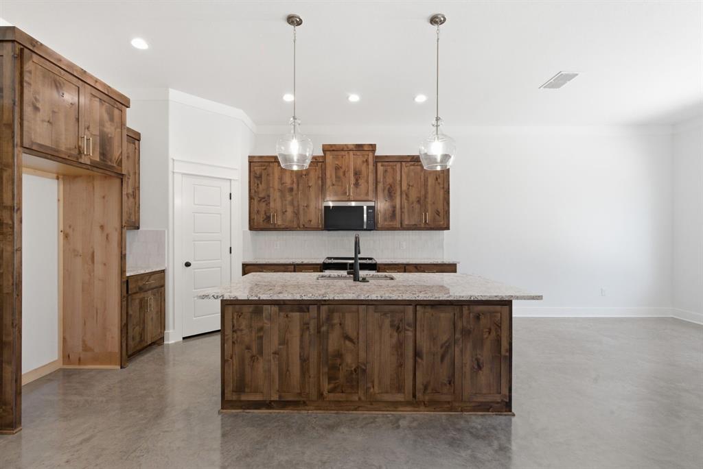 109 Graystone Weatherford, TX 76088 - Photo 5 of 26 a kitchen with stainless steel appliances granite countertop a sink a refrigerator and a stove