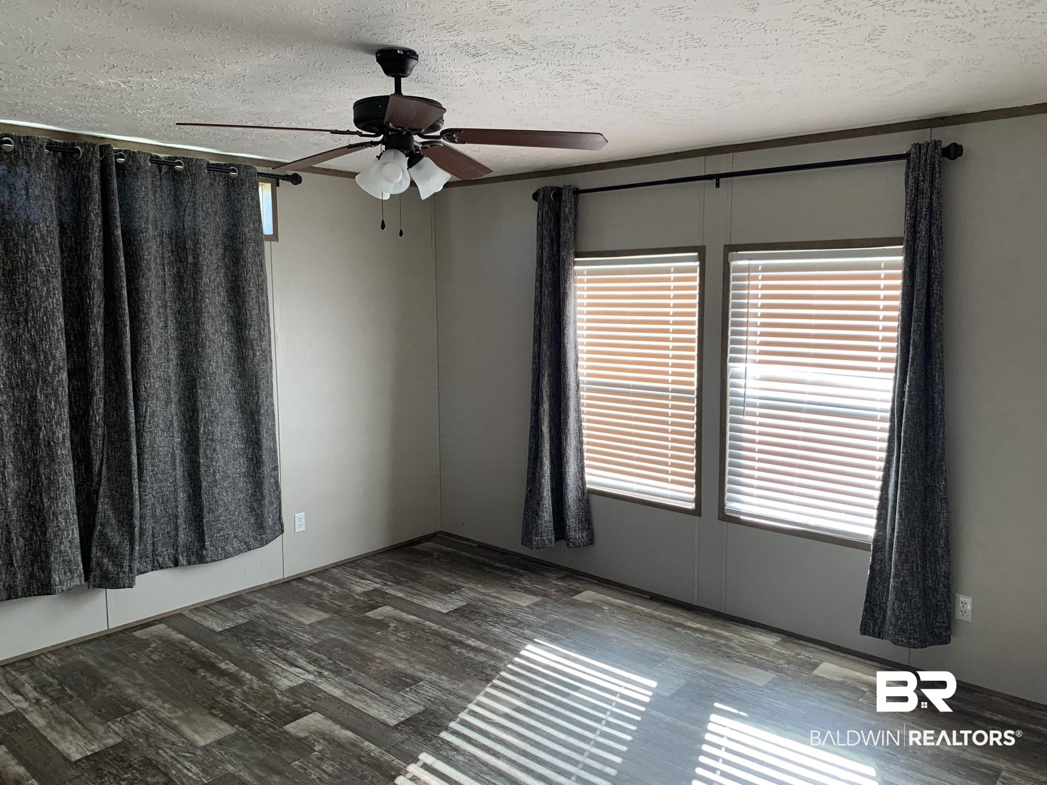 16876 County Road 87 Elberta, AL 36530 - Photo 2 of 13 Empty room featuring a textured ceiling, dark hardwood / wood-style flooring, and ceiling fan