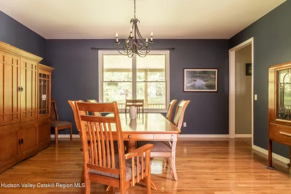 a dining room with furniture a chandelier and wooden floor