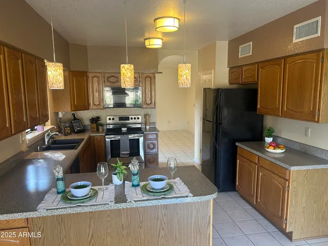 a kitchen with stainless steel appliances granite countertop a sink stove and cabinets