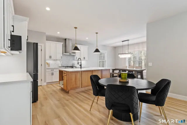 a kitchen with stainless steel appliances granite countertop a sink a stove and a wooden floors