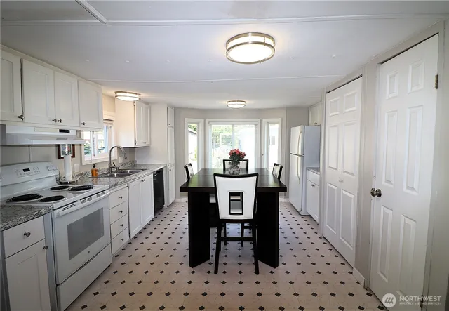 a kitchen with granite countertop a sink cabinets and stainless steel appliances