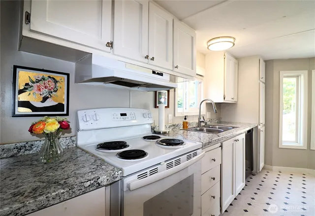 a kitchen with stainless steel appliances a stove a sink and a refrigerator