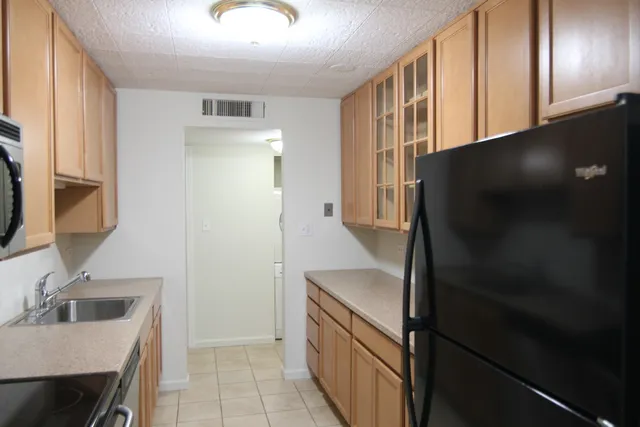 a kitchen with stainless steel appliances granite countertop a refrigerator and a sink