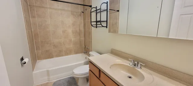 a bathroom with a granite countertop sink a toilet and shower