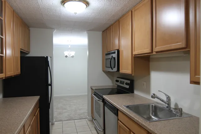 a kitchen with stainless steel appliances granite countertop a refrigerator and a sink