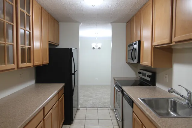 a kitchen with stainless steel appliances a sink stove and refrigerator