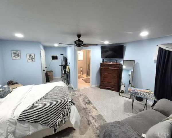 a bedroom with a bed a television and a large window