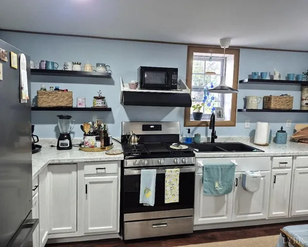 a kitchen with stainless steel appliances granite countertop a stove and a microwave
