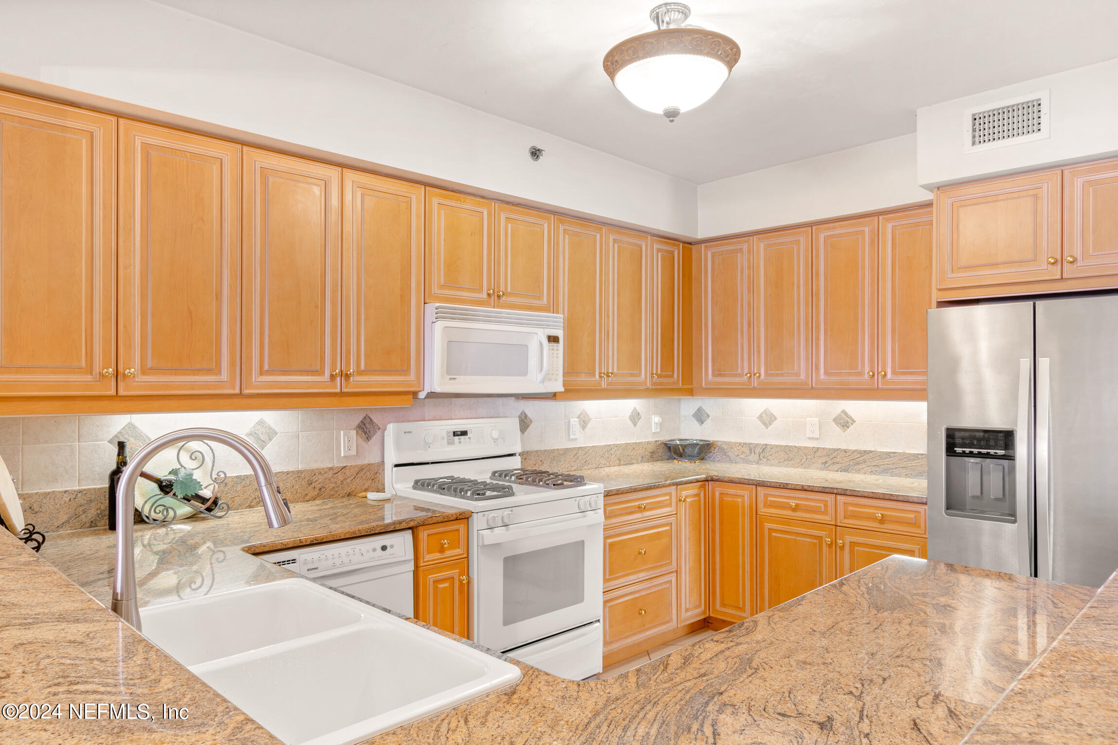7790 A1A South, Unit 101 St. Augustine, FL 32080 - Photo 19 of 79 a kitchen with stainless steel appliances granite countertop a sink stove and refrigerator