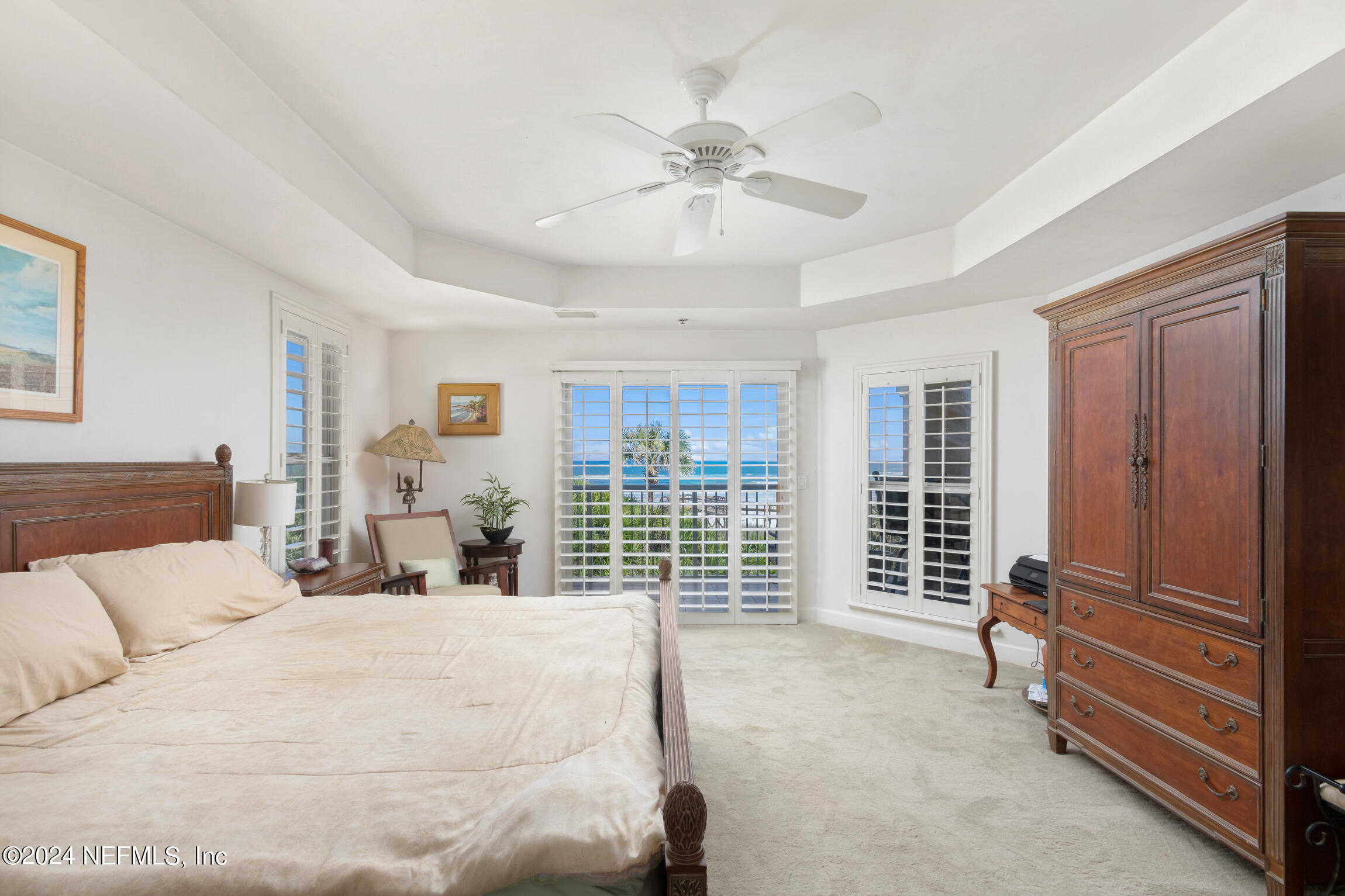 7790 A1A South, Unit 101 St. Augustine, FL 32080 - Photo 21 of 79 a bedroom with a large bed and a chandelier