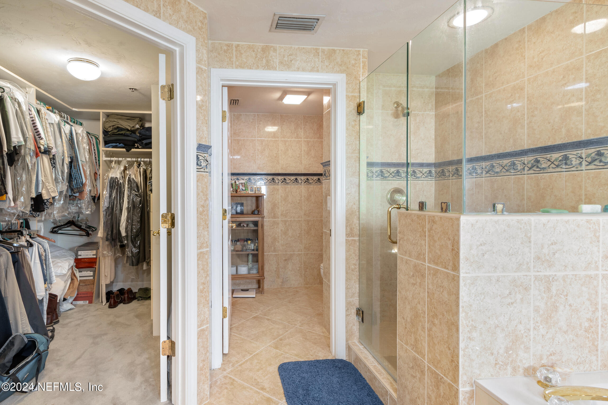 7790 A1A South, Unit 101 St. Augustine, FL 32080 - Photo 25 of 79 a bathroom with a glass shower door a sink and a mirror