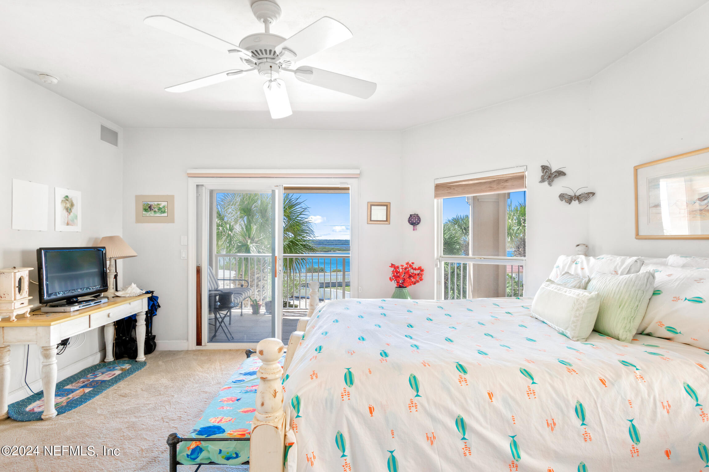 7790 A1A South, Unit 101 St. Augustine, FL 32080 - Photo 35 of 79 a bedroom with a bed a chandelier and a flat tv screen