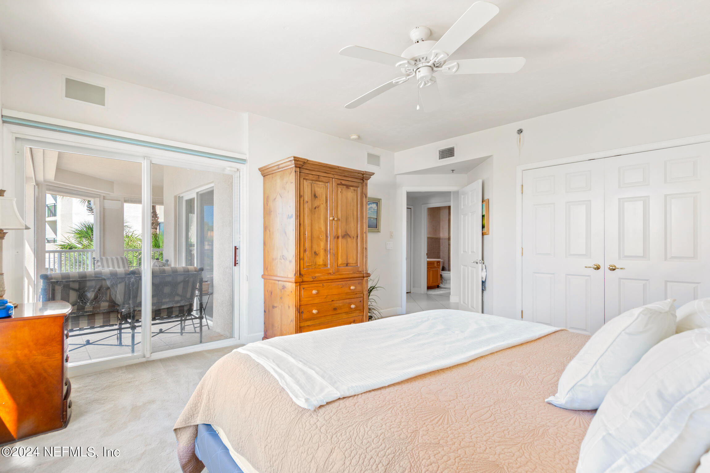 7790 A1A South, Unit 101 St. Augustine, FL 32080 - Photo 40 of 79 a bedroom with a large bed and a chandelier