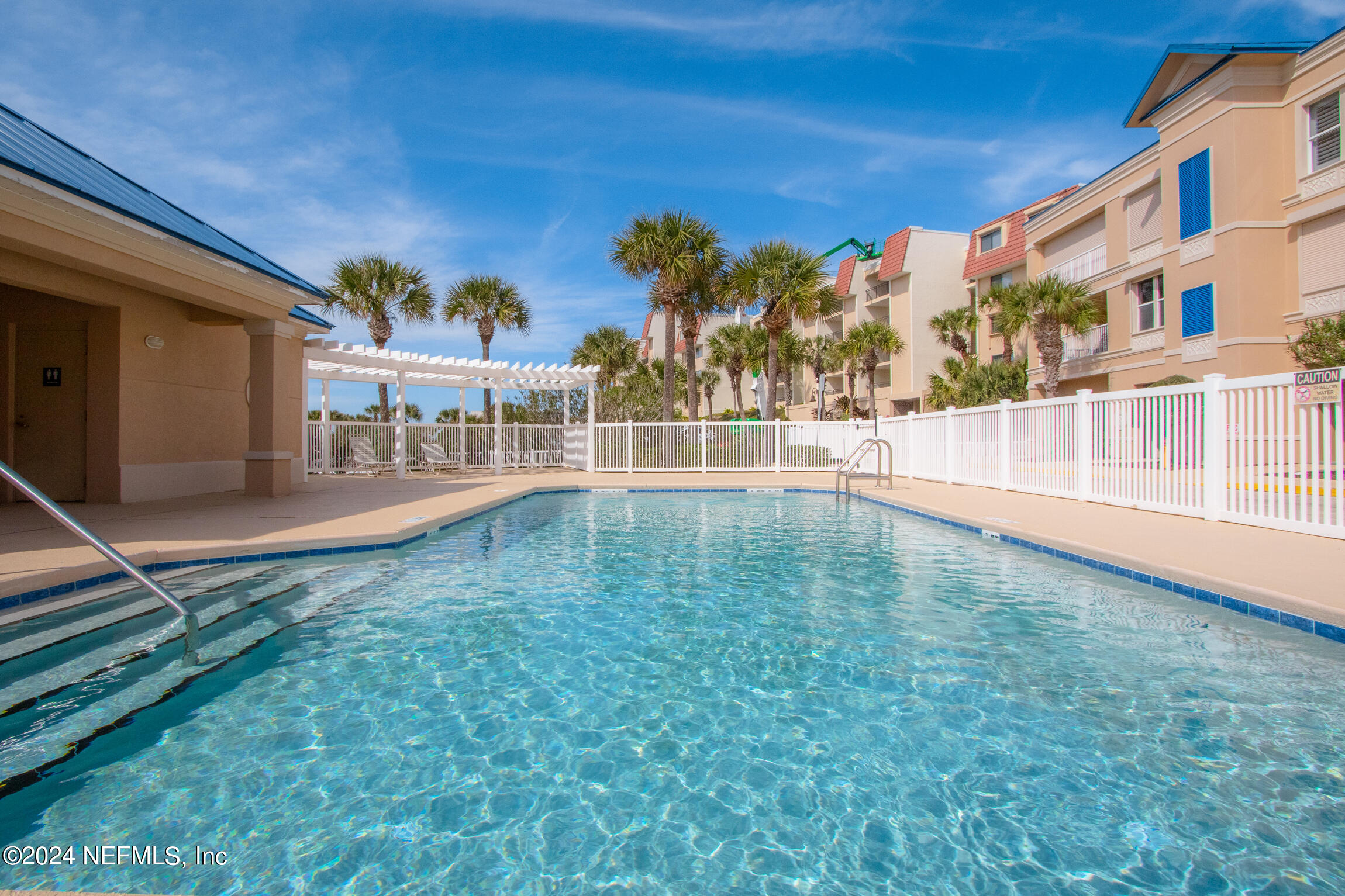 7790 A1A South, Unit 101 St. Augustine, FL 32080 - Photo 52 of 79 a view of a swimming pool with a lawn chairs