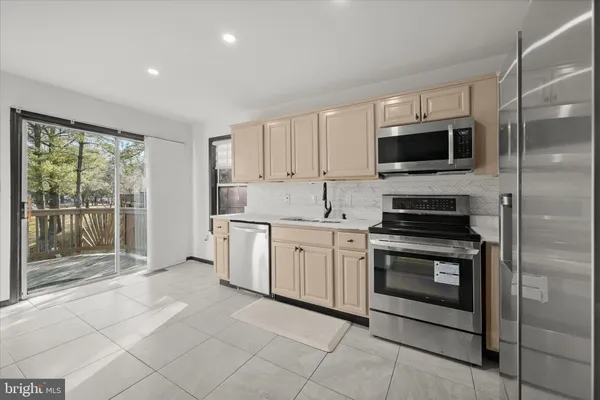 a kitchen with stainless steel appliances granite countertop a stove a microwave and a sink