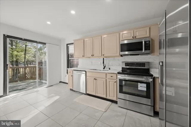 a kitchen with stainless steel appliances granite countertop a stove a microwave and a sink