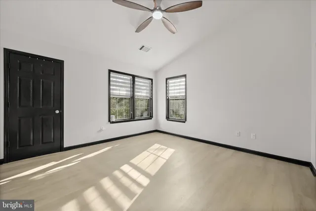 a view of an empty room with a window and a ceiling fan