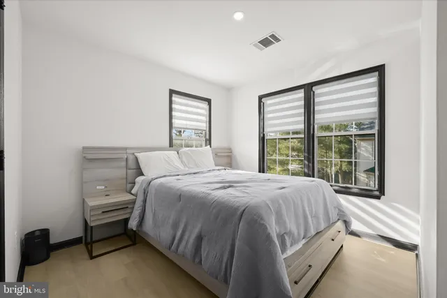 a spacious bedroom with a bed and a large window