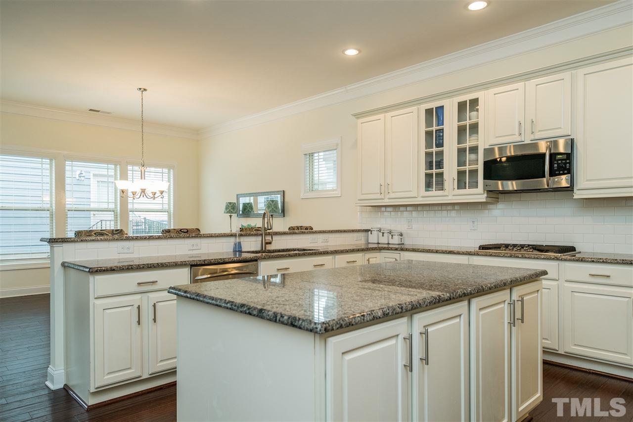 5616 Wade Park Boulevard Raleigh, NC 27607 - Photo 8 of 30 Dream kitchen features granite counters, two ovens, gas range, stainless appliances, white subway tile backsplash, huge island, bar, and tons of cabinet space!