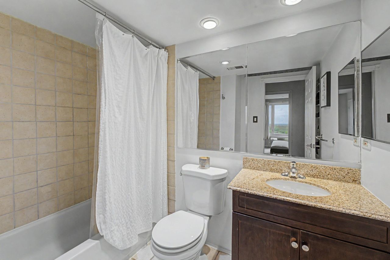 1 Renaissance Place, Unit 1105 Palatine, IL 60067 - Photo 15 of 21 a bathroom with a granite countertop sink a toilet a mirror and shower