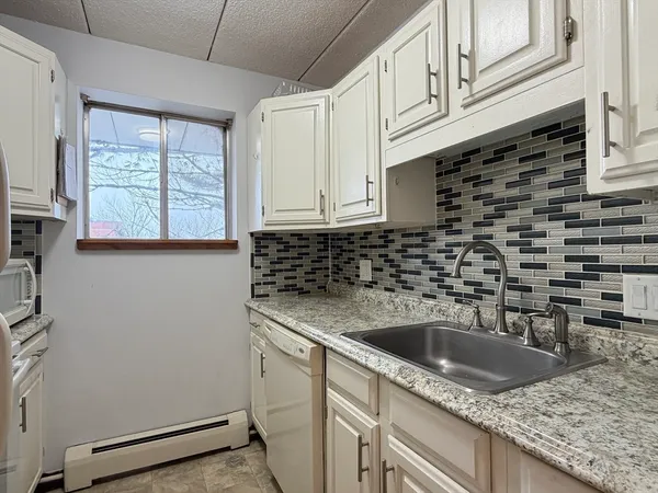 a kitchen with granite countertop a sink and a window