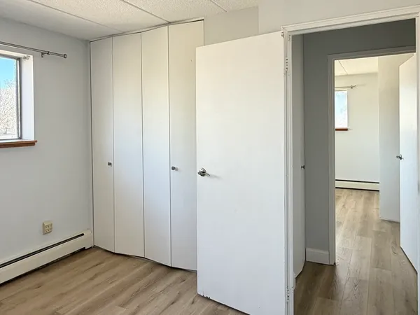 a view of an empty room with wooden floor