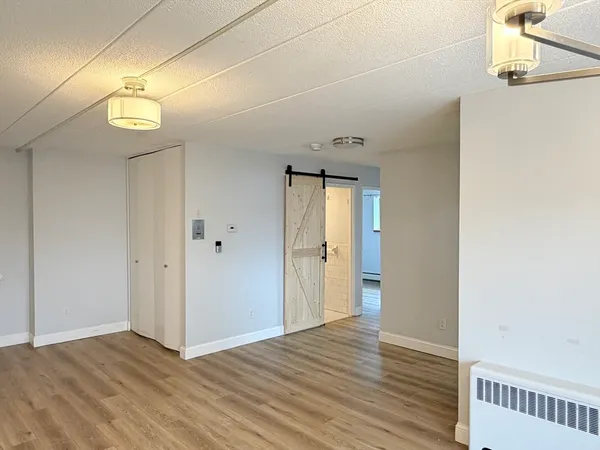 a view of an empty room with wooden floor