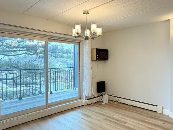 a view of a livingroom with wooden floor a ceiling fan and window