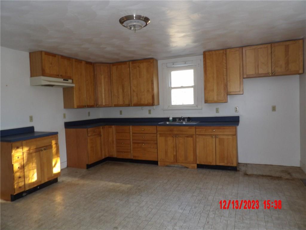 935 Mercer Grove City Road Mercer, PA 16137 - Photo 7 of 17 a kitchen with granite countertop a stove a sink and a microwave